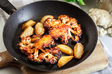Vegetarian roasted cauliflower steak with herbsand fried potatoes