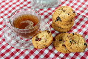 cup of tea with cookies on  checkered napkin red and white