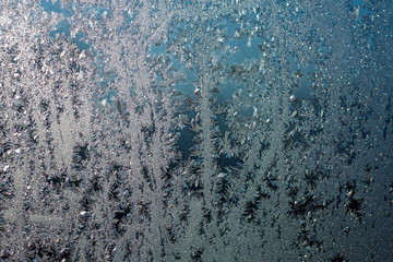 Ice patterns on glass, frost on a winter window, fancy patterns of winter.