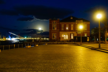 Fototapeta premium 夜明け前の広場と橋と煉瓦の建物と空に月