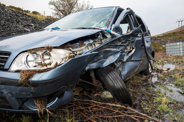 Total loss car with broken windscreen, axle fracture and police barrier band