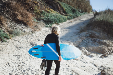 surfer with flippers and a bodyboard in a hydro suit on the ocean shore © Yuliya Kirayonak