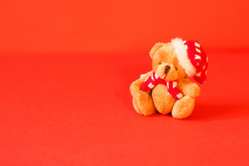 Cute, dressed in red cap and tie Teddy Bear, red background
