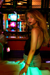 Pretty blond girl in arcade, portrait