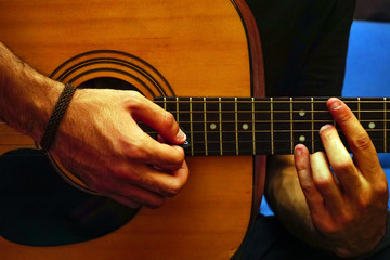 Playing guitar hands on the strings close up view