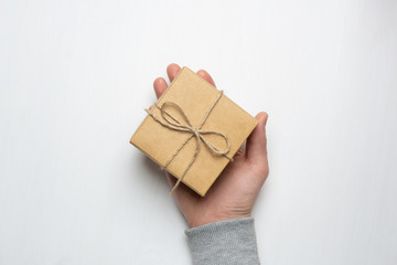 man's hand holds a gift in a box on a white background