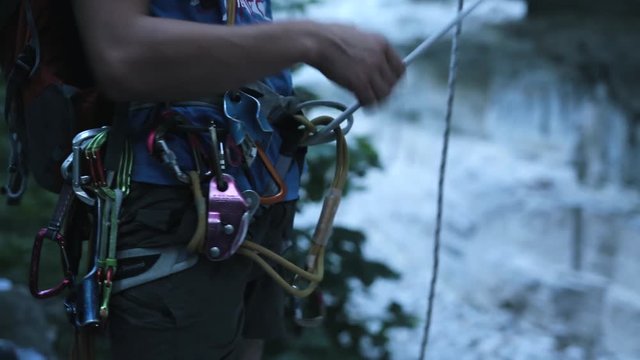 man climber untie the rope from himself and take off his gear