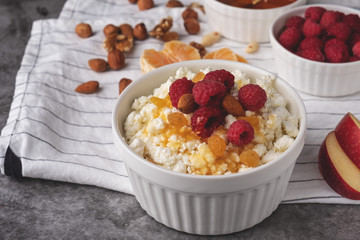 cottage cheese with fresh berries, honey, apples,  tangerines, and nuts, healthy breakfast, diet vegetarian food