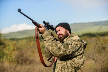 Aiming skills. On my target. Bearded hunter spend leisure hunting. Hunting optics equipment for professionals. Brutal masculine hobby. Man aiming target nature background. Hunter hold rifle aiming