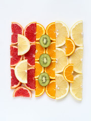 Creative squared pattern of sliced fruits - kiwi, orange and grapefruits, flat lay style