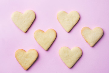 Homemade cookies in the shape of a heart on a pastel pink background. Copy space. Concept Valentine's Day