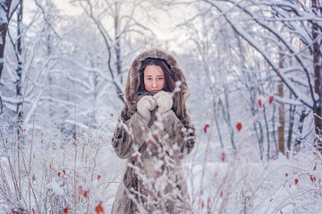young woman in winter forest, snowinf and cold winter, girl in fur coat, warm clotes, looking...