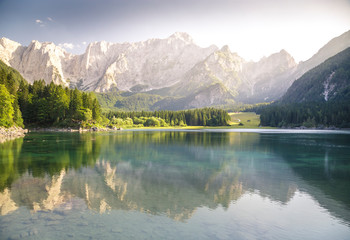 Fototapeta na wymiar Superior Fusine Lake with Mount Mangart on the background. Fusine Lakes Natural Park, Tarvisio, Udine province, Friuli Venezia Giulia, Italy.