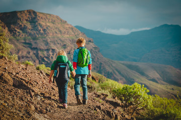 boy and girl travel in mountains, family hiking in nature