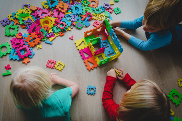 kids playing with number and shapes puzzle