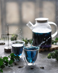 glass of blue tea on stone table