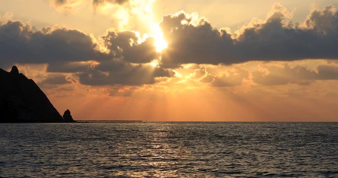 Wonderful sunset. on the Turkish beach. Calm blue sea, beautiful clouds, wonderful mountains.