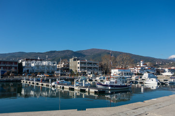 Fototapeta na wymiar Harbor with boats and fishing schooners. Platamonas (Greek) is a sea-side resort and fishermans village in south Pireia, Central Macedonia.