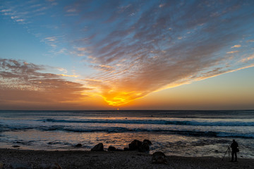 Photographer shooting the sunset on the beach