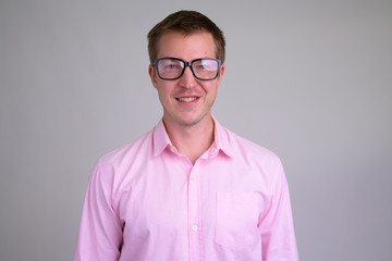 Face of happy young nerd businessman smiling with eyeglasses