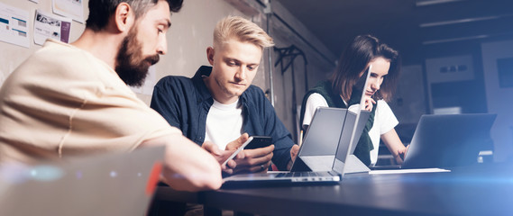 Young professional give some new ideas about project to his partners in meeting room. Business people discussing over new business project in office