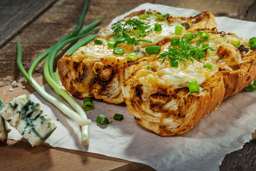 Delicious open-face grilled cheese sandwich made of cheese and baguette. Homemade fast food. .