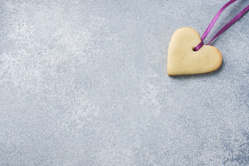 Obraz premium Homemade cookies in the shape of a heart on a grey background. Copy space. Concept Valentine's Day