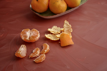 Naklejka na ściany i meble Fresh tangerine citrus or mandarin with leaves on orange background