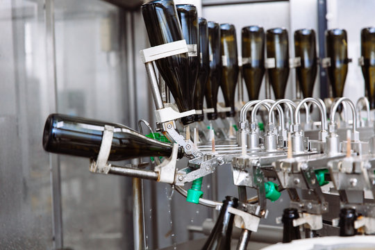 Glass bottles on the automatic conveyor line at the champagne or wine factory. Plant for bottling alcoholic beverages.