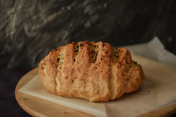 Handmade loaf bread on wooden table and on dark background