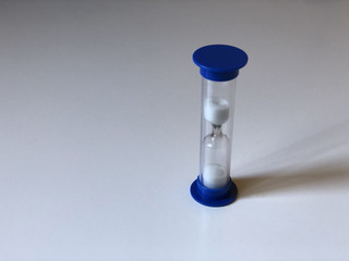 Blue hourglass on white background. Time. Macro