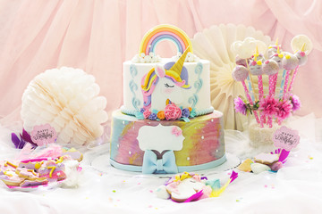 Little girl's birthday party  dessert table with unicorn cake, cake-pops, sugar cookies and birthday decoration © hiddencatch
