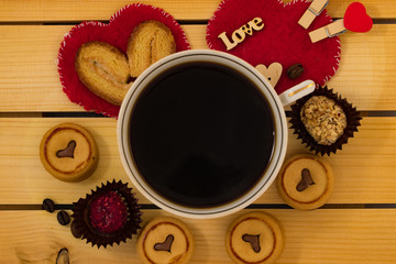 Cup of coffee and cookies on wooden background.