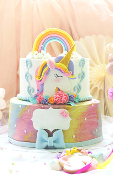 Little girl's birthday party; dessert table with unicorn cake, cake-pops, sugar cookies and birthday decoration