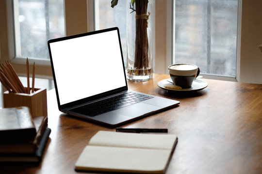 Mockup laptop computer on wooden table.