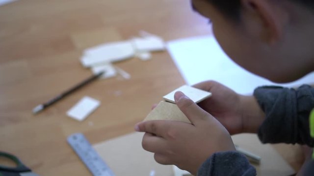 School children are working on woodwork. With a knife cutter and a ruler as a working device, Wood processing