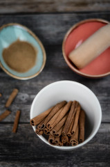 Cinnamon sticks and powder on rustic wooden background