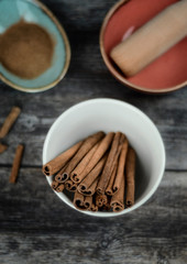 Cinnamon sticks and powder on rustic wooden background