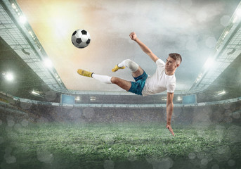 Fototapeta na wymiar Soccer player on a football field in dynamic action at summer day