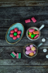 Many different yummy candies on wooden background. Top view