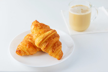Croissants with a cup of coffee on a white table