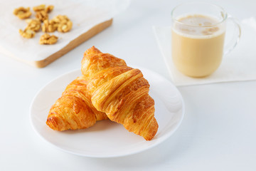 Croissants with a cup of coffee on a white table