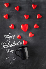 Heart shaped candies and black cup.