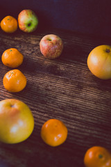 healthy fruit including oranges grapefruit and apples on dark wooden surface with copyspace