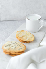 Homemade cat's tounge cookies with milk on marble background. Langues de chat.
