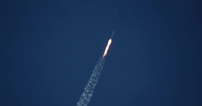 Nuclear missile flying through blue sky with exhaust flames and smoke in 4K.