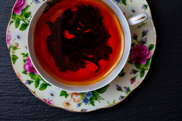 top view of  tea in porcelain cup on on slate tray 