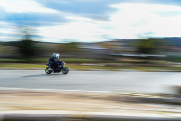 Motorbike passing with panning effect on the road