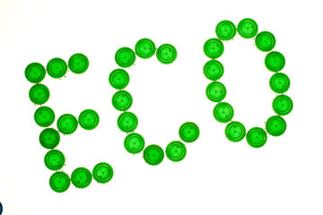 Recycling concept with Eco caption made of green plastic bottle caps
