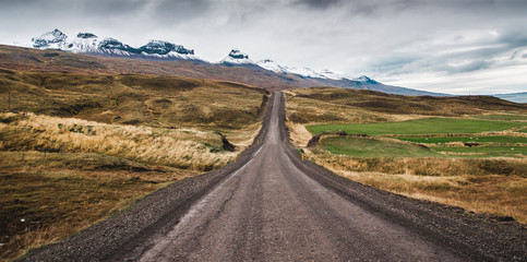 Gravel road in the snowy mountains of Iceland after a rainy day with mud